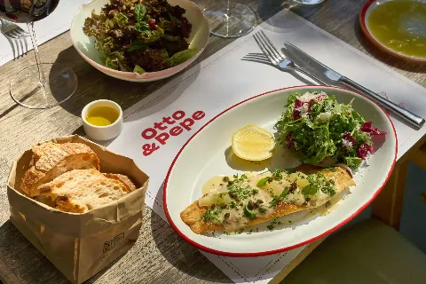 Italian grilled fish with lemon and fresh salad at Otto & Pepe restaurant in Miami