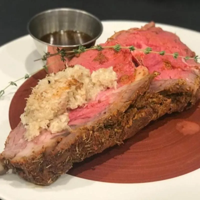 A prime rib dinner on a restaurant table.