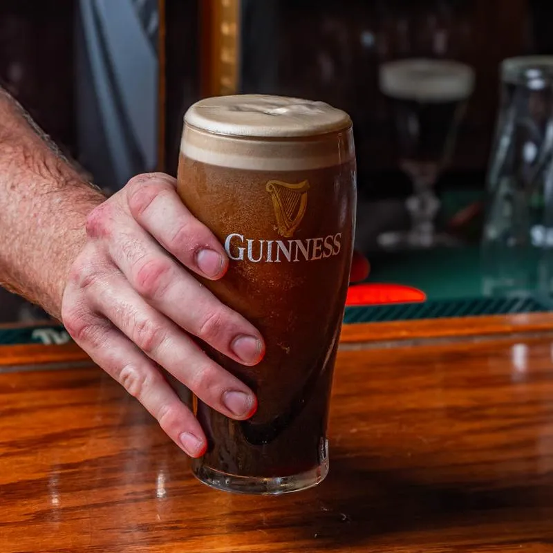 Bartender placing a glass of beer on bar counter