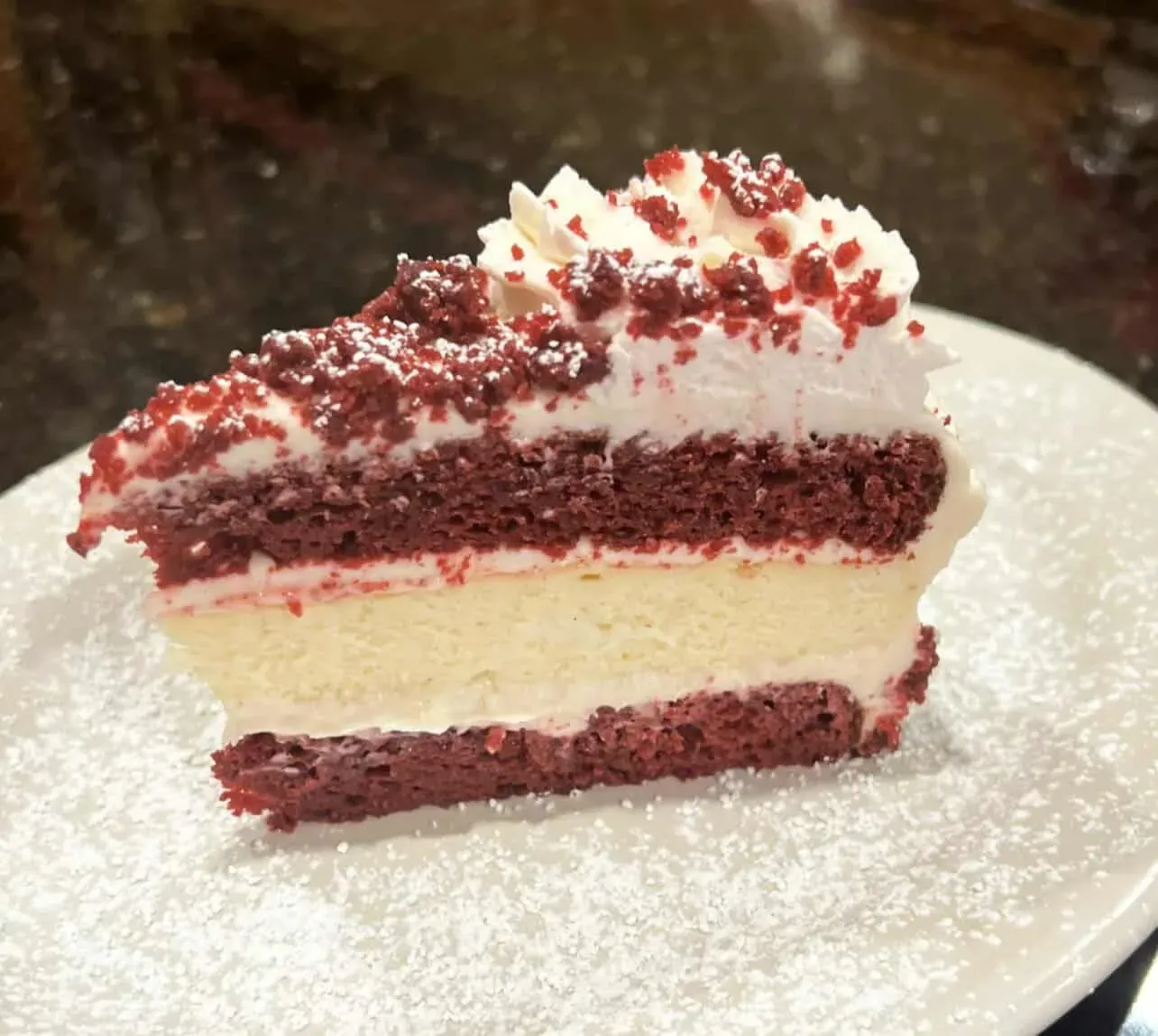 Slice of red velvet cheesecake with whipped cream