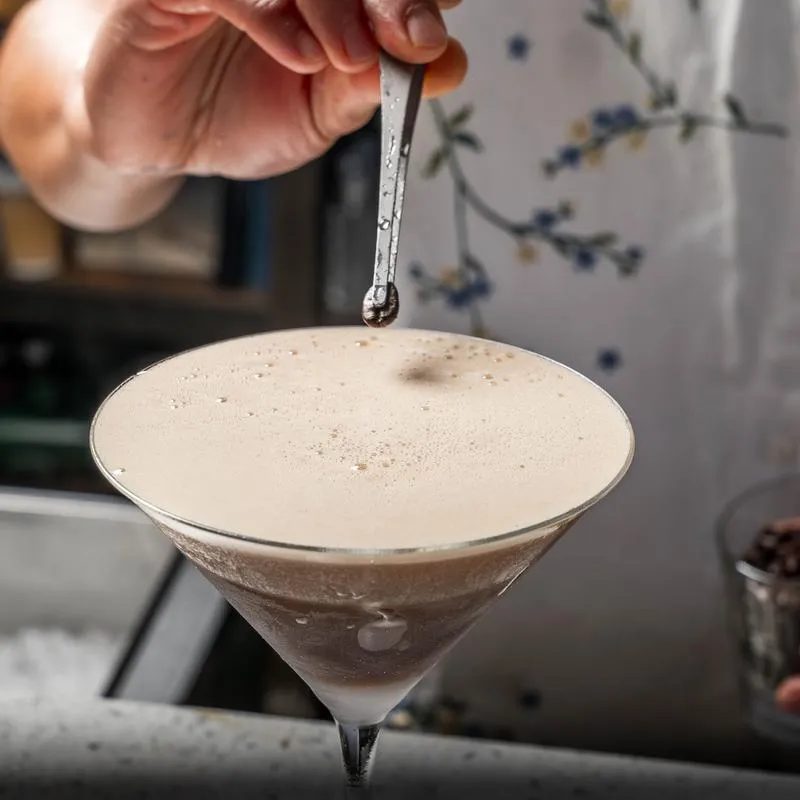 Foamy cocktail being stirred.