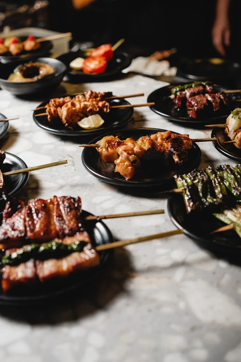 various grilled skewers displayed on the pass