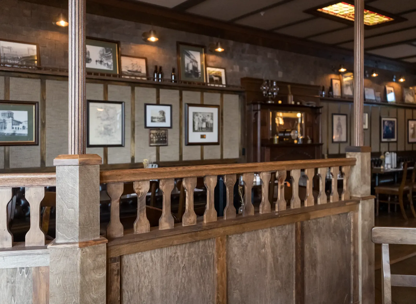Wooden balustrade and framed photographs in the dining room at Delany's Public House.