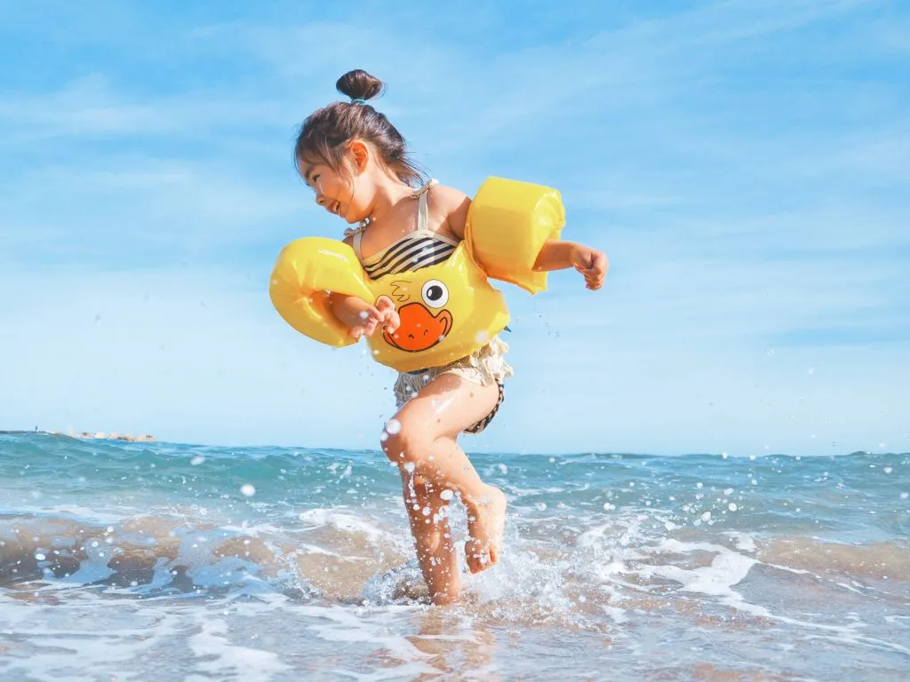 A Girl Jumping In The Air With A Toy In Her Hand
