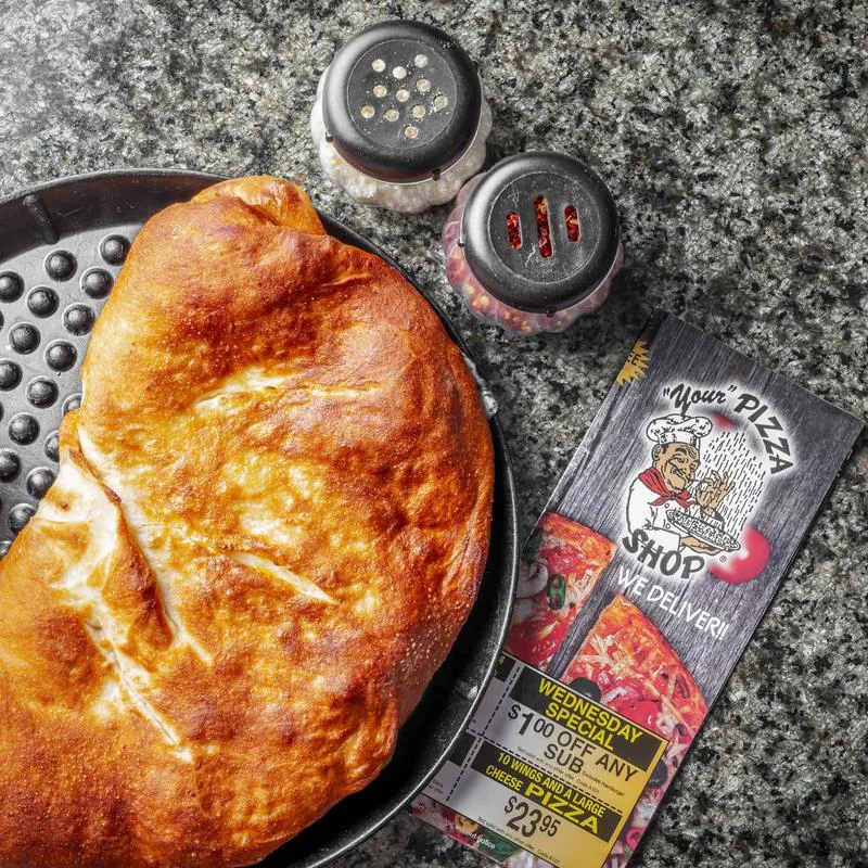 Cheese calzone on a dark plate.