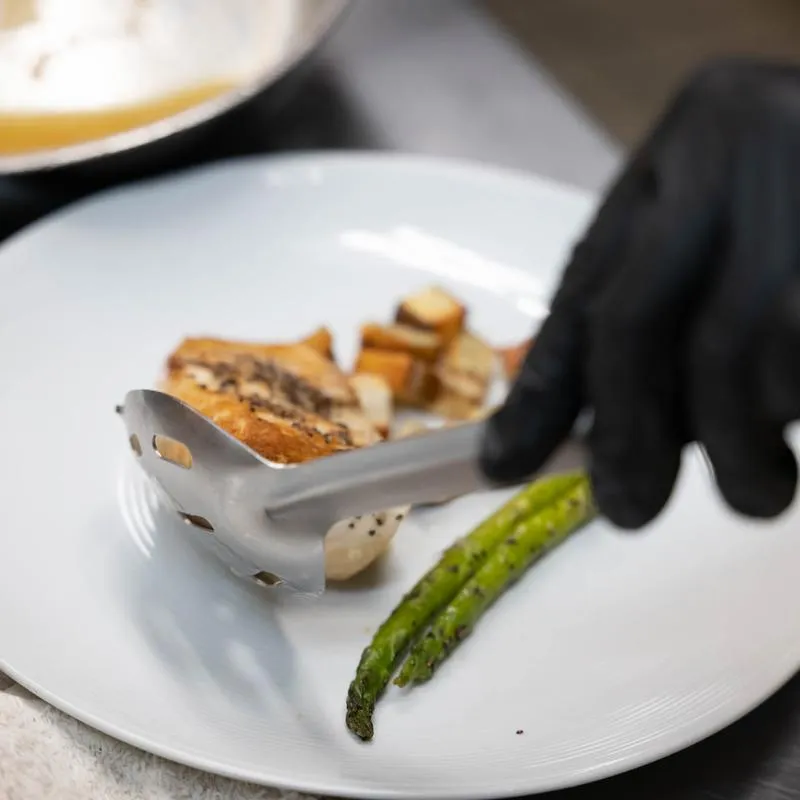 Close up, serving food on plate.