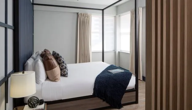 A Bedroom With A Bed And A Lamp