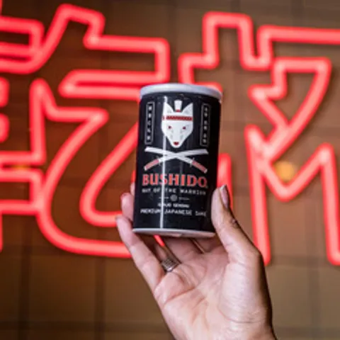 A hand holding a canned drink.