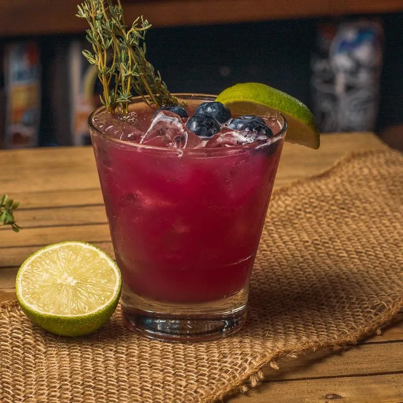 Blueberry thyme margarita with lime slice.