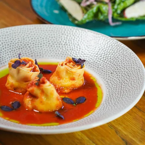 Rose shaped pasta with red and green sauce.
