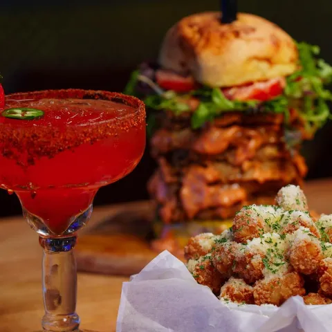 Strawberry Jalapeño Margarita served alongside Park Truffle Tots and stacked burger.