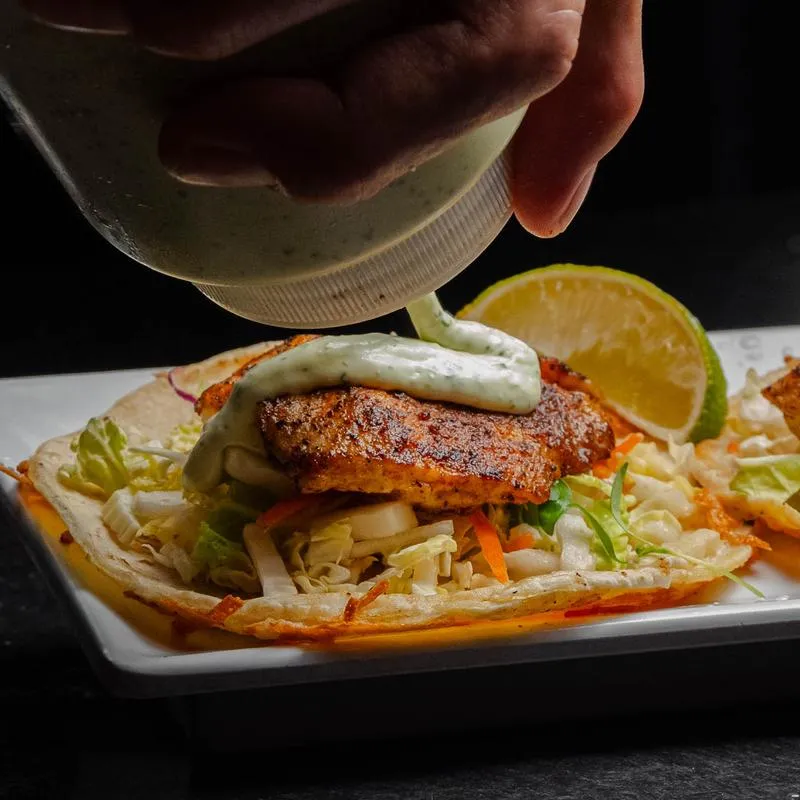 Wasabi aioli sauce is added to an ahi tuna taco.