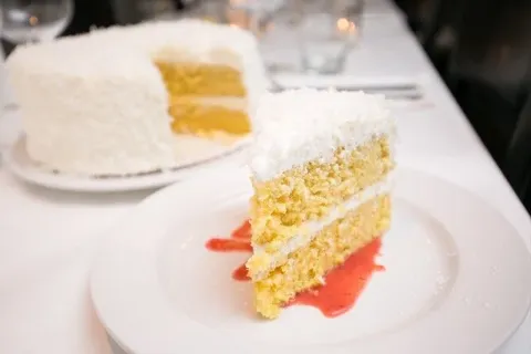 Slice of coconut cake on a white plate
