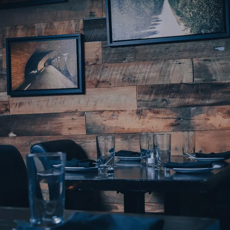 Bar table ready for guests, decorative wooden wall with details in the background