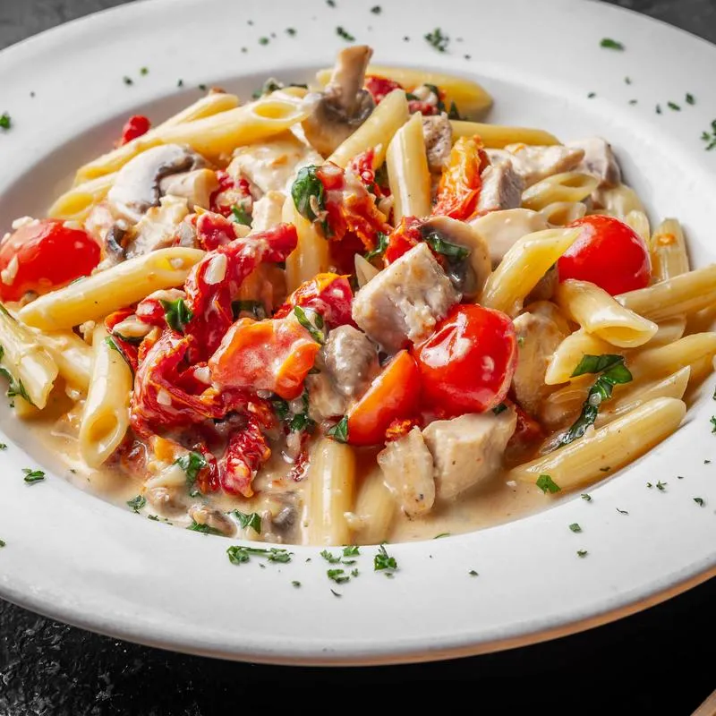 Penne pasta with chicken, tomatoes, and creamy sauce.