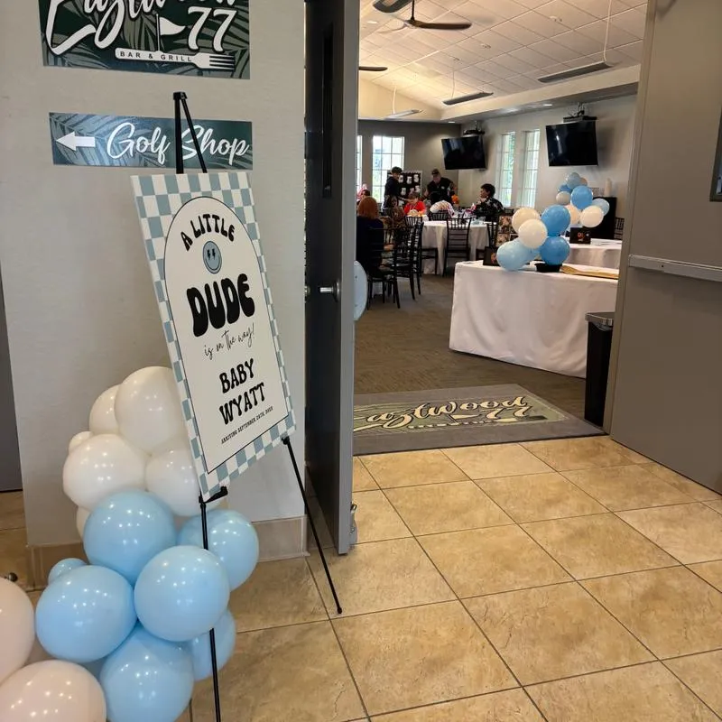 Baby shower welcome sign on the entrance with blue and white balloons.