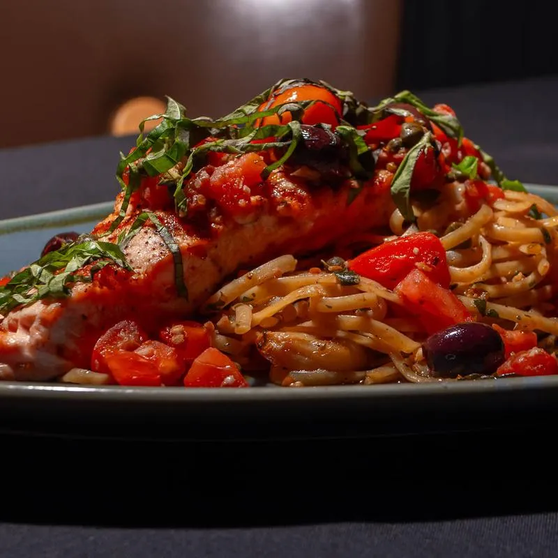 Salmon Livornese, with cherry tomatoes, garlic, capers, Kalamata olives, and linguine pasta.