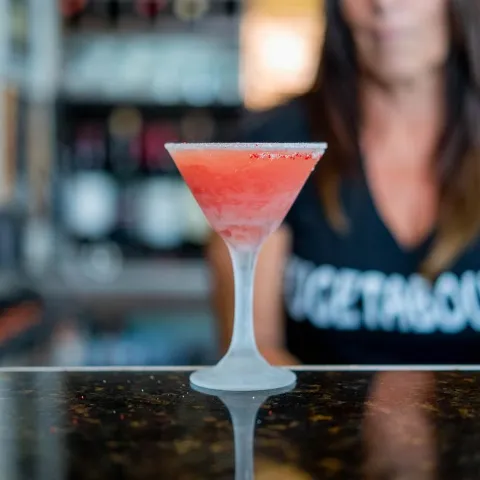 Cocktail in a frozen martini glass served on the bar.