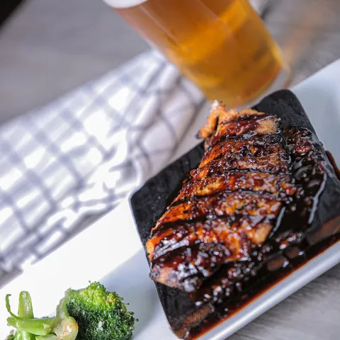 Grilled meat, green vegetables and glass of beer.