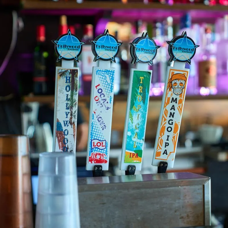 Row of four draft beer tap handles mounted on a bar counter.