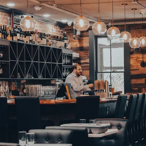 Bar area with part of dining room in front, bartender
