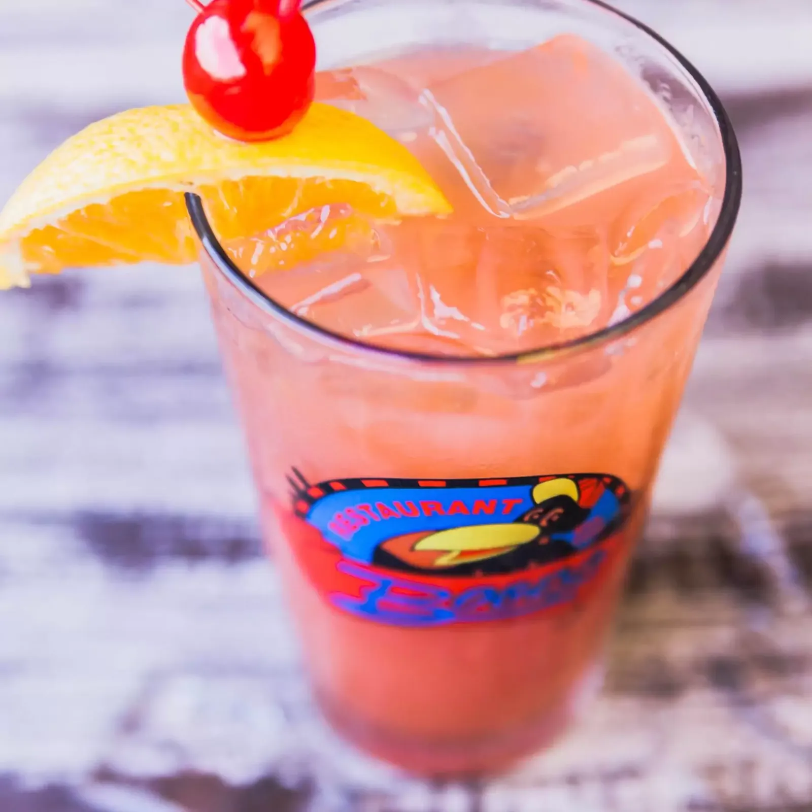 Signature cocktail in a Bogey's branded glass with orange slice and cherry garnish served at Bogey's Sports Pub in Venice, FL