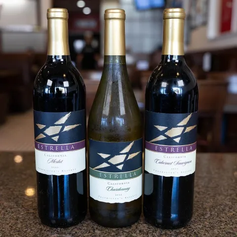 Three wine bottles displayed on a granite tabletop.