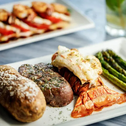 Surf and Turf, with Filet Mignon, lobster tail, baked potato, and asparagus.
