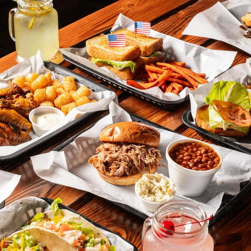 Assorted sandwiches with sides and drinks on a table.