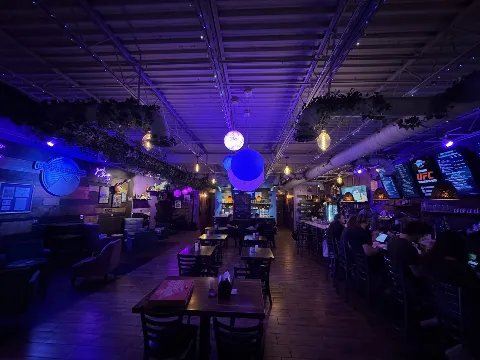 Moon Mountain lounge interior with planet lamps, tables and live-event stage lighting