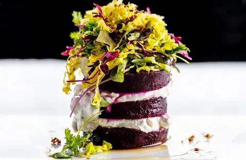 Stacked beet salad with cheese and mixed greens