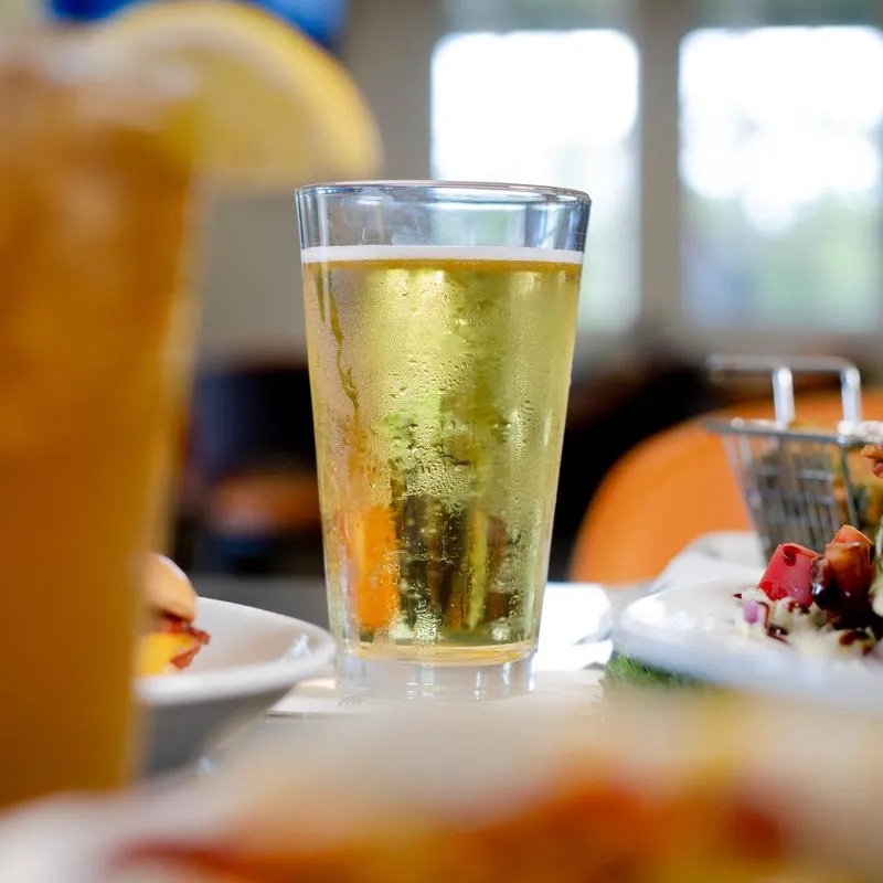 Glass of beer served alongside food.