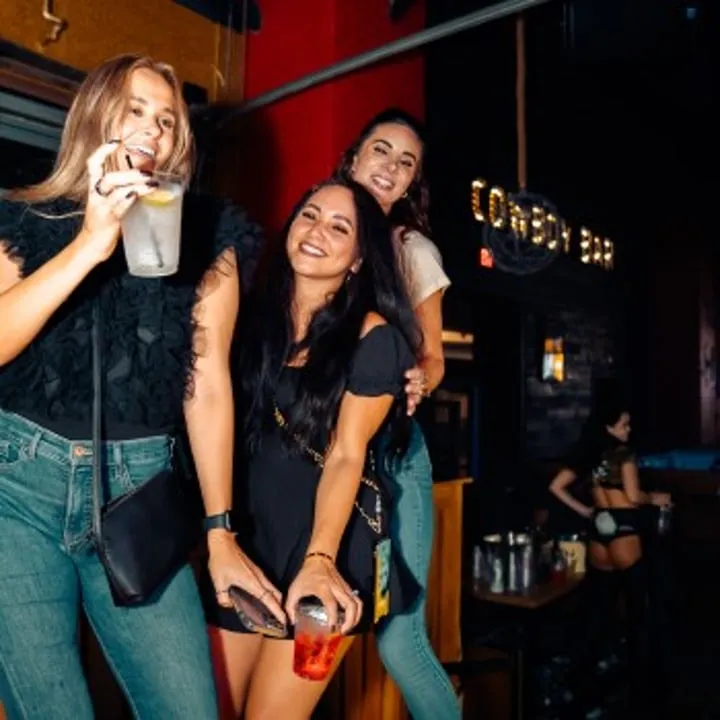 Three women dancing at PBR Cowboy Bar at Live! at the Pointe Orlando.