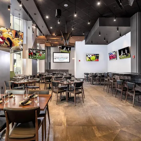 Interior, tables, chairs, paintings, TV screens.