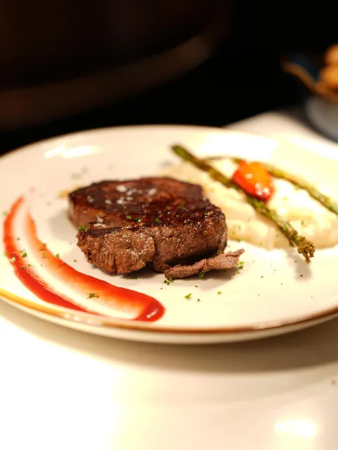 Plated steak with mashed potato, asparagus and roasted pepper at Madrid Tapas y Vinos