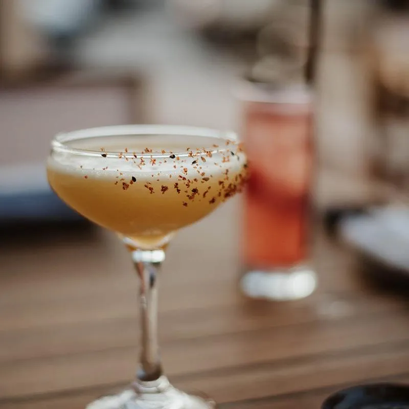 A cocktail served in a stemmed coupe glass.