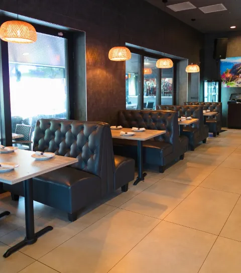 Acropolis Greek Taverna main dining room with booth seating and tables.