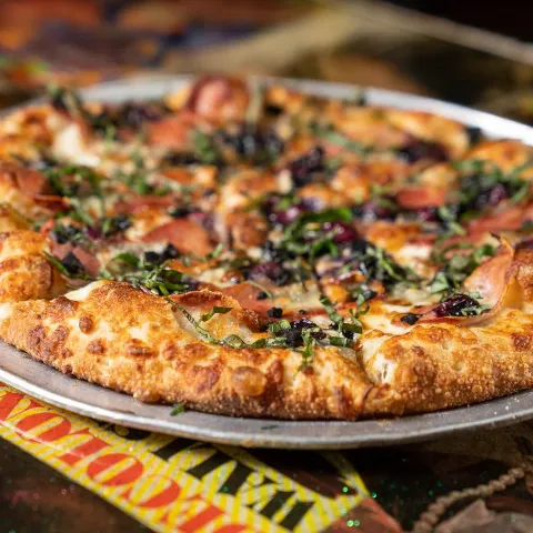 Black Gold pizza with black garlic, prosciutto, seasonal fruit and cheeses