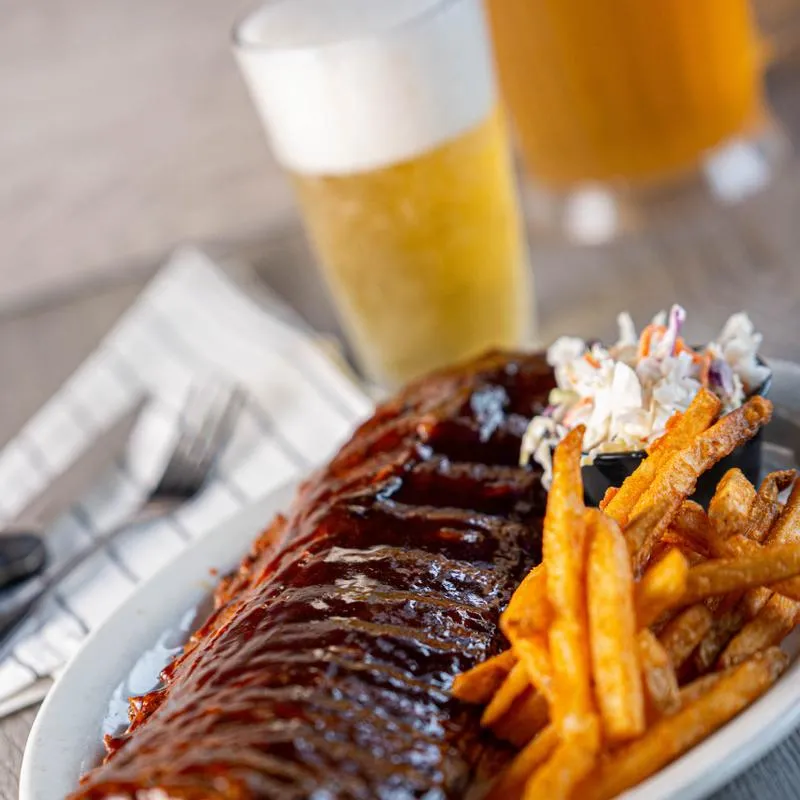 Grilled meat, fries and glass of beer on the side