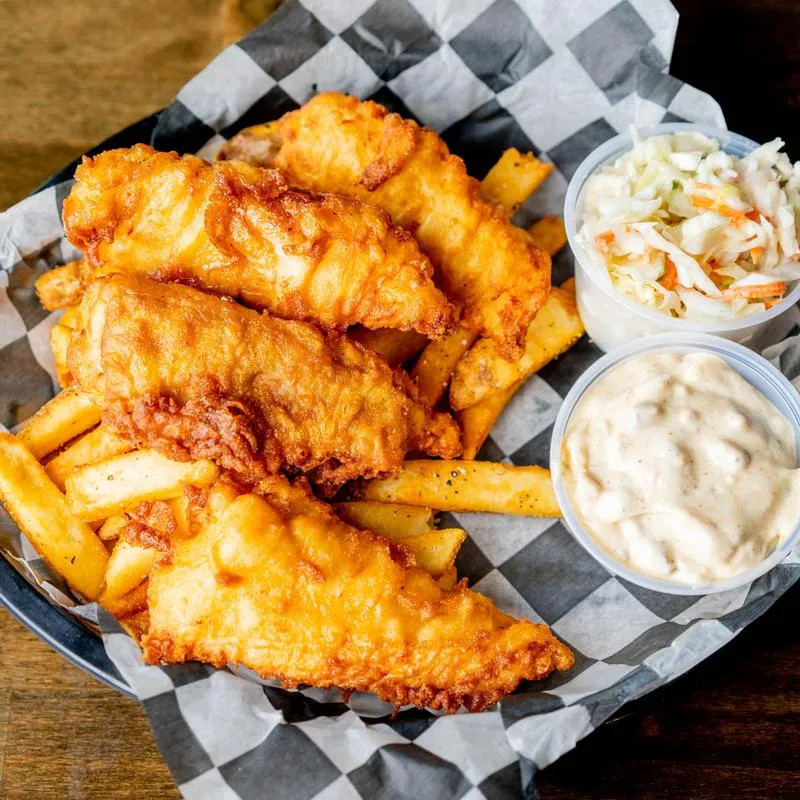 Fried fish and fries served with coleslaw and tartare sauce.