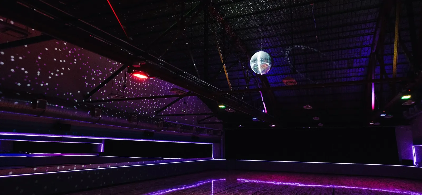 Indoor roller skating rink at Primrose Lanes with colorful lighting and a disco ball