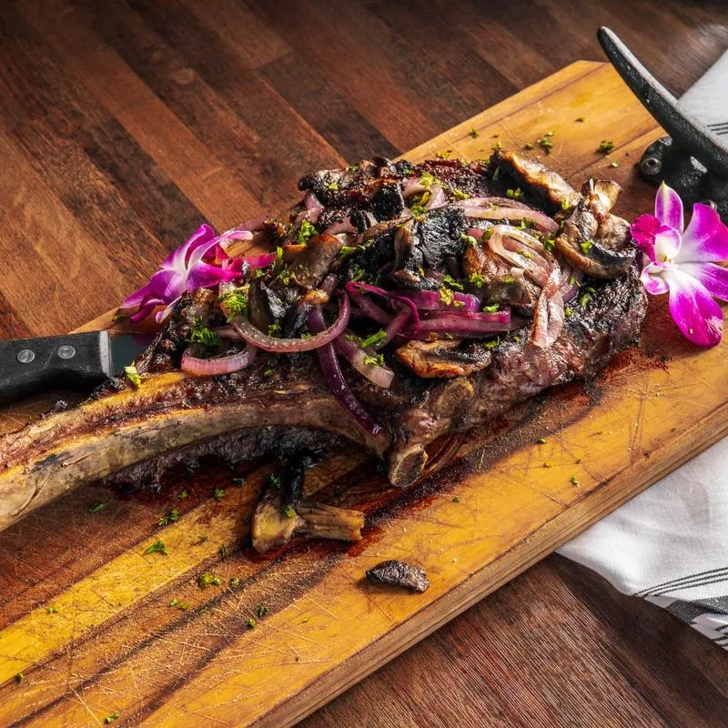 Tomahawk steak on a wooden board.