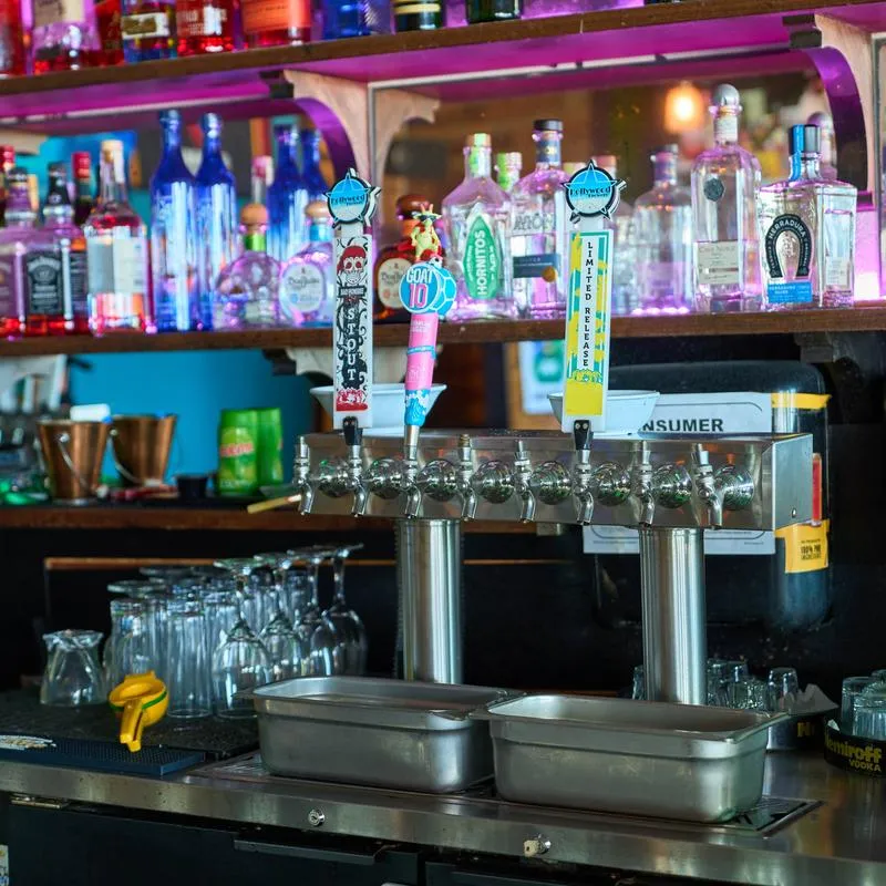 Back bar featuring a multi-tap draft beer dispenser system and a lit back shelf.