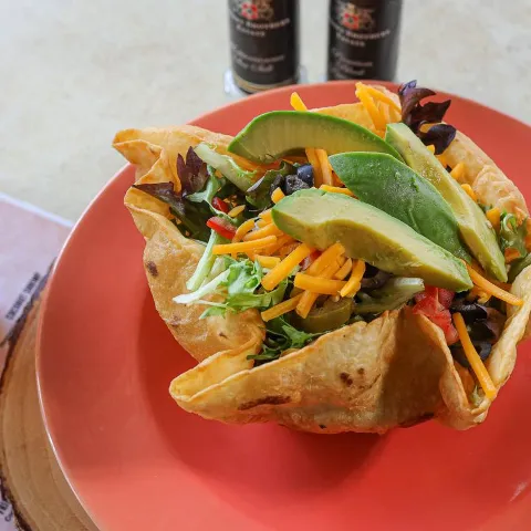 Taco salad, with olives, cheddar, tomato, onions, pickled jalapenos and avocado