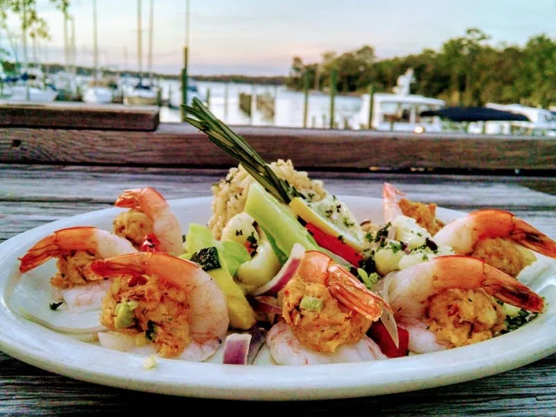 Crab stuffed shrimp dinner on plate overlooking bay