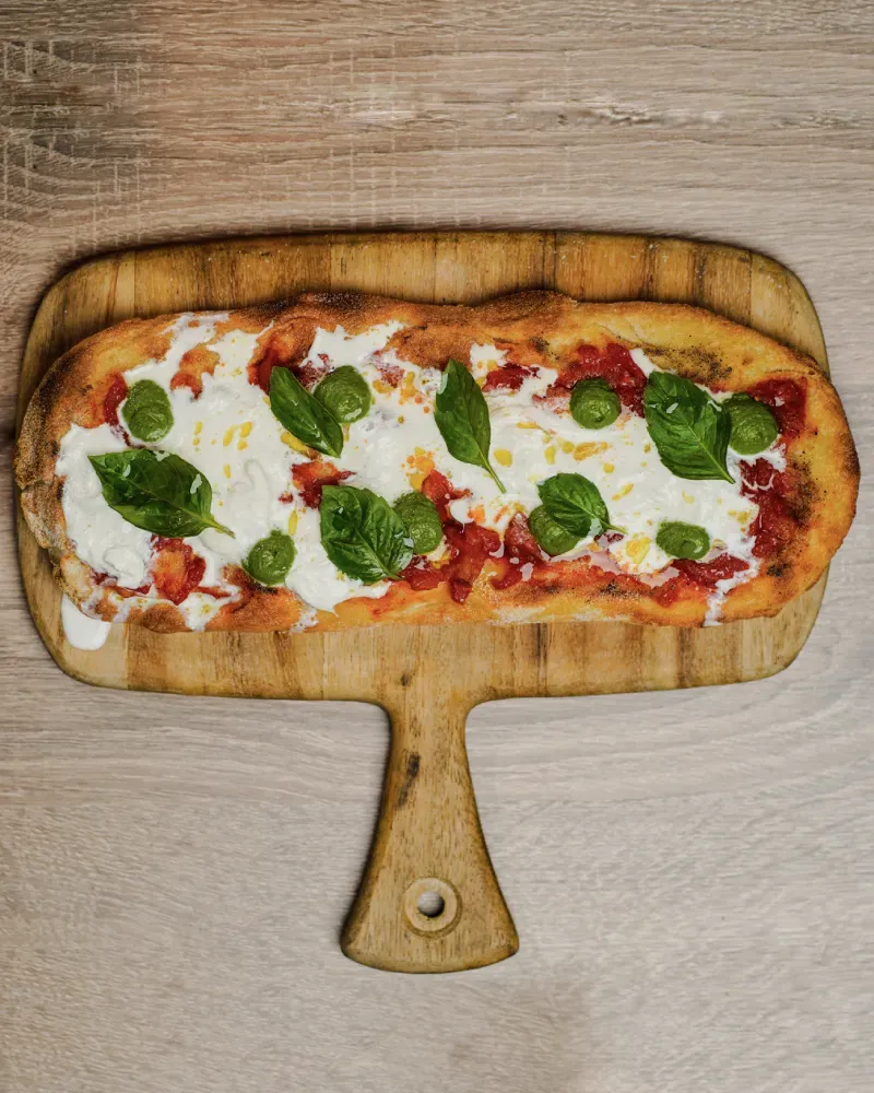 A pizza sitting on top of a wooden cutting board.