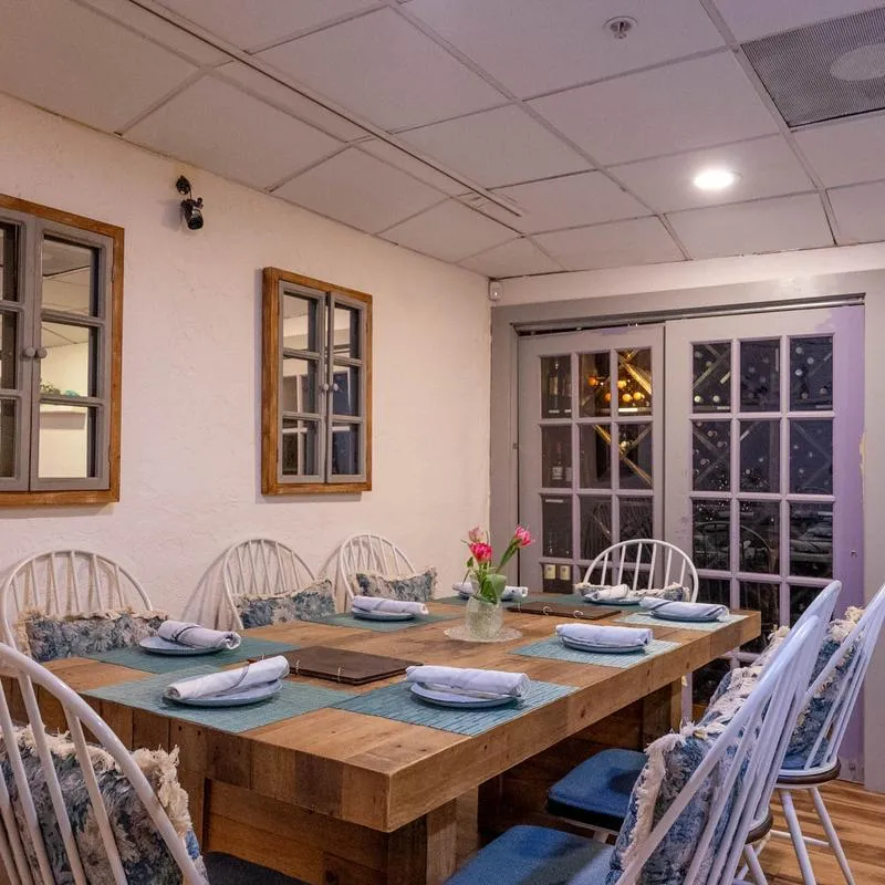 Room corner with a private table set with tableware and comfortable chairs.