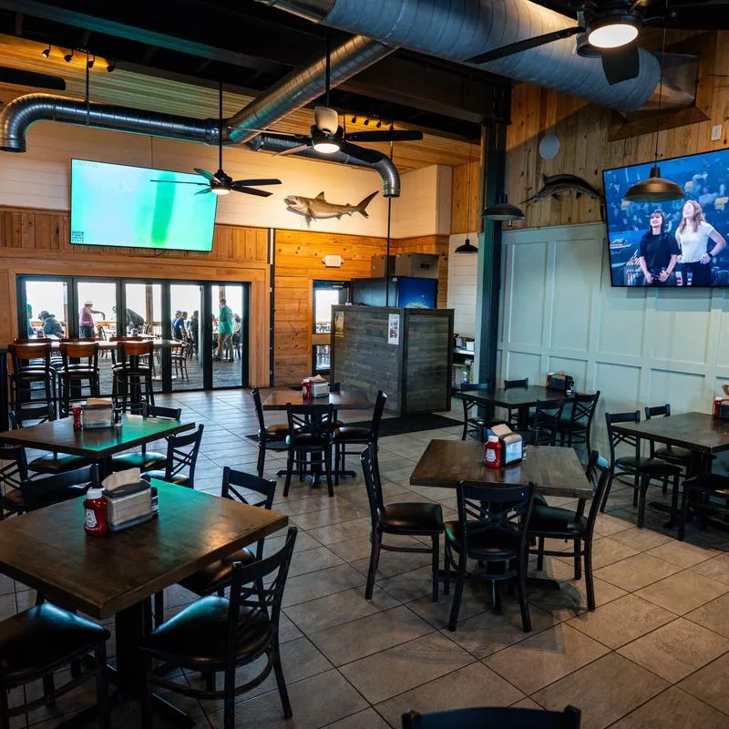 Interior - wooden furniture, tiled floors, mounted televisions and nautical decor.