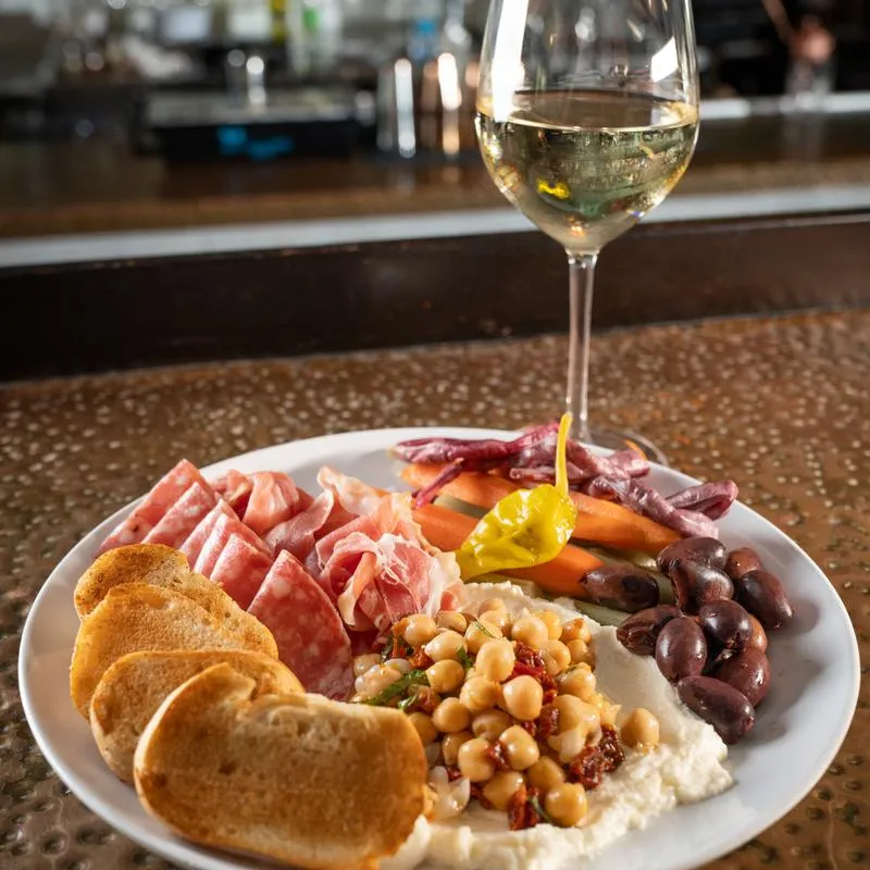 Antipasto platter, white wine in the glass.