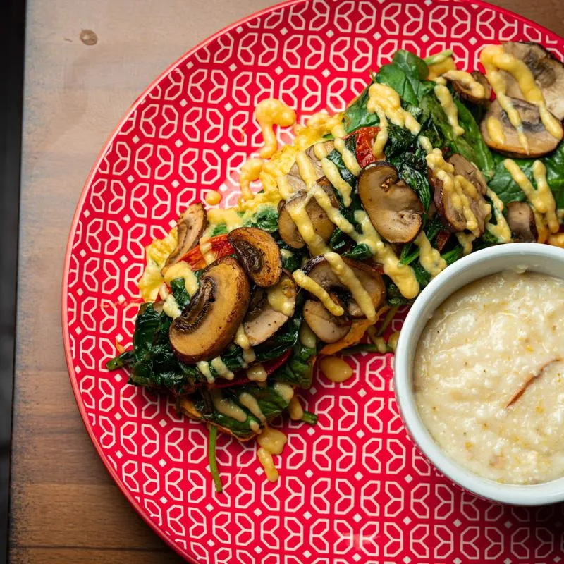 Spinach and mushroom omelet with a bowl of grits.